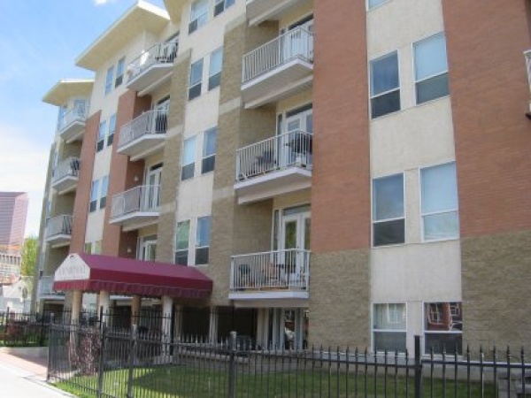 A building with balconies and a fence in front of it.