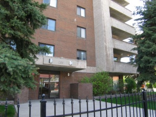 A building with a fence and trees in front of it