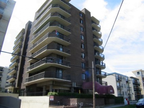 A large brown building with many windows and balconies.