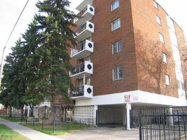 A large brick building with trees in the background.